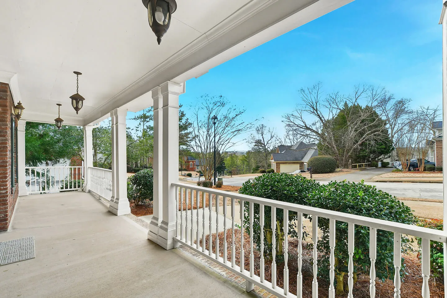 Covered front porch view overlooking quiet suburban neighborhood